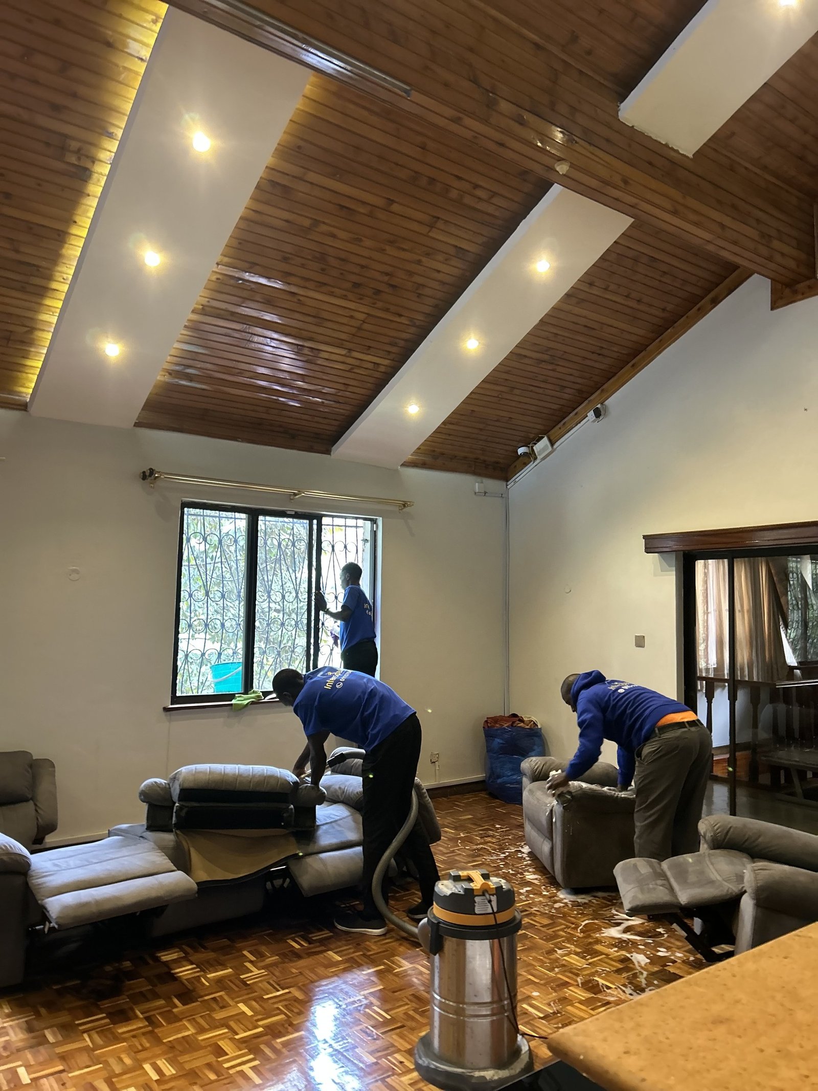 Intersparkle crew deep cleaning a living room with parquet floors