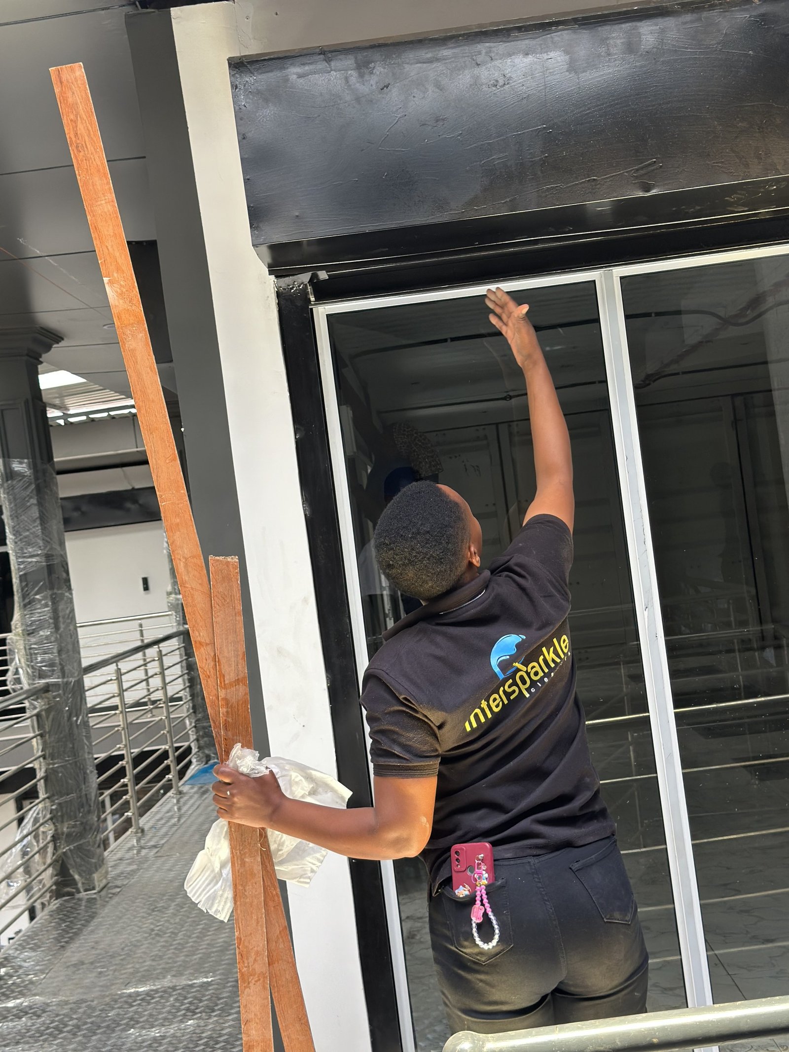 Cleaner wiping a new glass shower screen