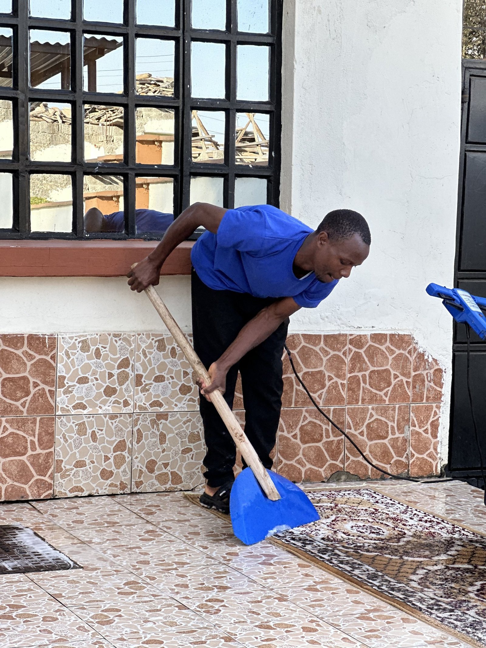 Cleaner shampooing a rug outdoors