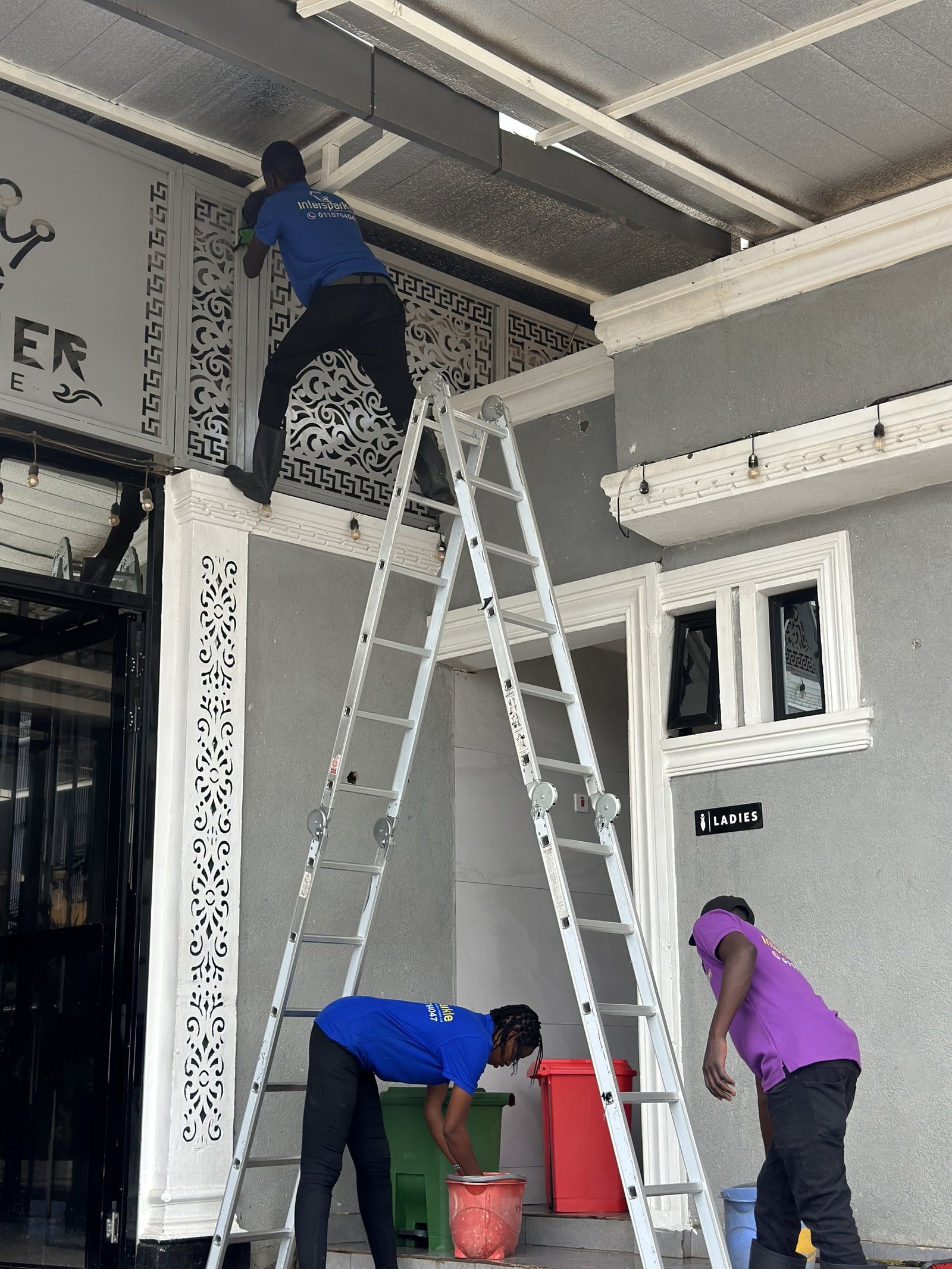 Cleaner on a ladder cleaning a high facade